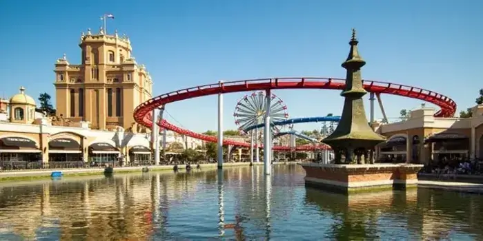 A vibrant theme park scene with thrilling rides, happy families, and iconic attractions.